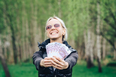 blonde made a fan out of a wad of Euros and showing off the money.の写真素材
