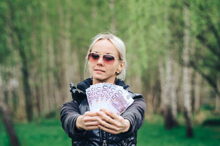 blonde made a fan out of a wad of Euros and showing off the money.の写真素材