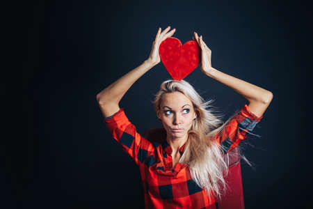 Happy girl with a Valentine heart on a black backgroundの写真素材