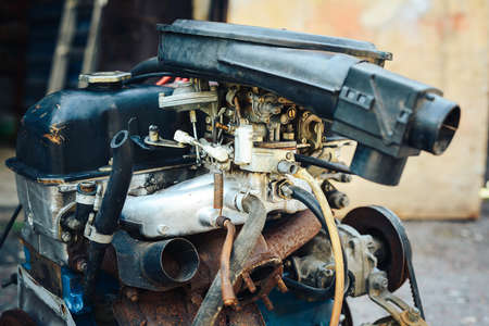 Close-up of an old engine removed from the car and lying near the garage.の写真素材