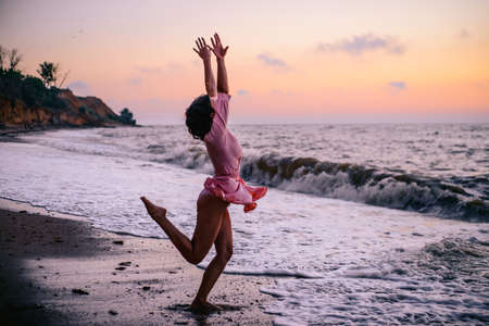 girl enjoys the sunrise on the beach.の写真素材