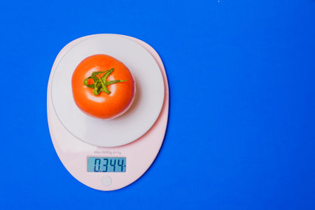 Fresh tomato on the scale. the concept of healthy eating, weight loss. 