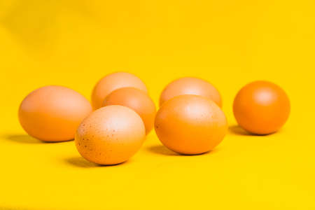 Close- up of six fresh village eggs on a yellow background.の写真素材