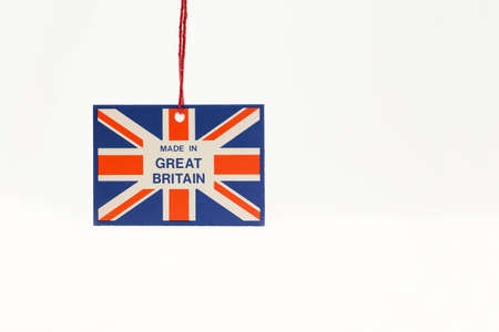 Cardboard tag on a string with a flag and the inscription made in great Britain. Close- up, white isolated background.の写真素材