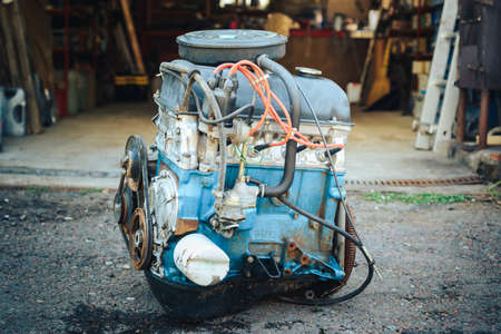 Close-up of an old engine removed from the car and lying near the garage.の写真素材