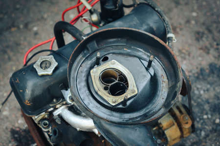 Close-up of an old engine removed from the car and lying near the garage.の写真素材
