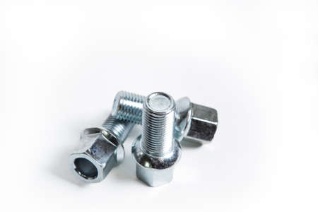 Three new car bolts on a white background, close-up selective focus.の写真素材