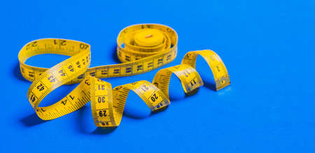 Roulette. Yellow meter to measure length and width on blue background. Selective focus.の写真素材