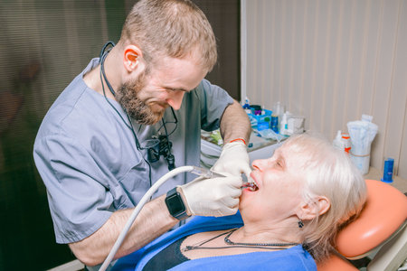 An elderly woman in a chair at the reception of a young male dentist.の写真素材