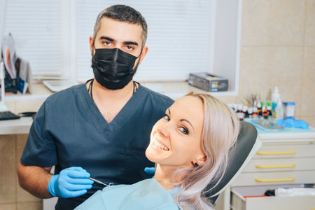 Smiling girl at the reception of a male dentist in a dental chair.の写真素材