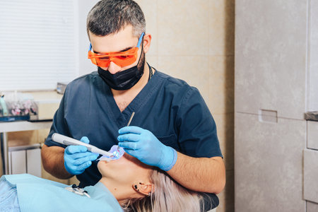 The dentist sets the patient's seal. A blonde girl at a dentist's appointment.の写真素材