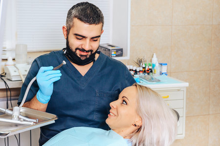 A frightened blonde girl at a reception at a cheerful, smiling dentist.の写真素材