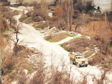Dump truck on a dirt road in the middle of the forestの写真素材