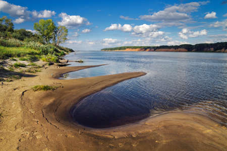 sandy river Bank covered with vegetationの写真素材
