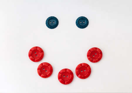 the sign of a smile lined with buttons on white backgroundの写真素材