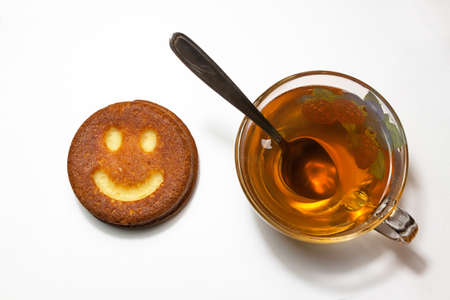 cookies in the shape of a smile and cup of tea  on white backgroundの写真素材