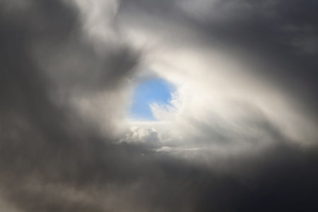 small area of clear blue sky in the clouds
