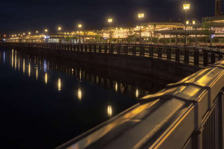 the city embankment illuminated by lanterns reflected in the riverの写真素材