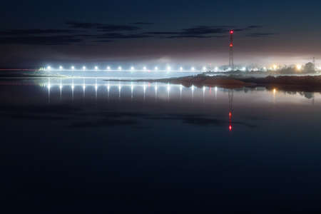 bridge with lanterns over the river at night in the fogの写真素材