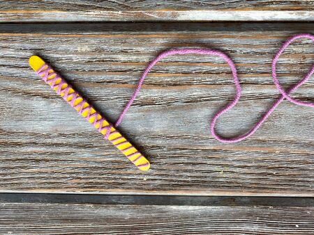 On a yellow wooden stick wrapped yarn, childrens craftの写真素材