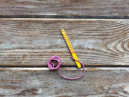 On a yellow wooden stick wrapped yarn, childrens craftの写真素材