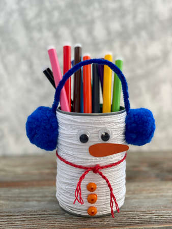 Snowman with headphones, childrens craft from a jar and thread, pencil stand.の写真素材