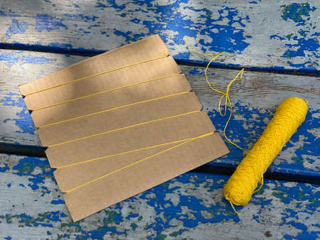 piece of cardboard recycling with yellow threads, kids craftの写真素材