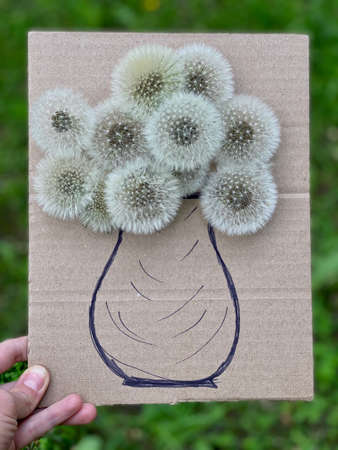 childrens art on a walk, flowers in a vase, made of cardboard and fluffy dandelions.の写真素材