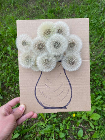 childrens art on a walk, flowers in a vase, made of cardboard and fluffy dandelions.の写真素材