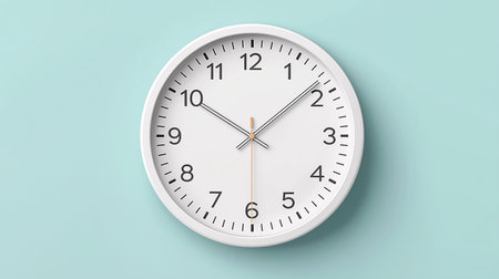 Round wall clock in white, with numbers, on a blue background.の写真素材