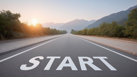 Golden sunlight illuminates an empty highway, boldly marked with the word START, evoking feelings of hope, new beginnings, and limitless possibilities.の写真素材