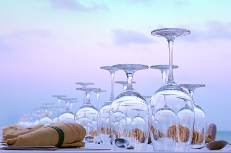 Festively decorated table with glasses against the evening skyの写真素材