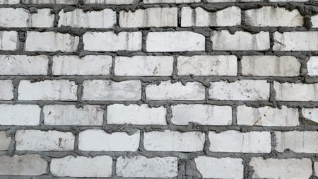 Newly finished white brick wall with visible mortar joints in a construction site settingの写真素材