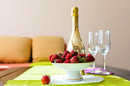 Bottle of wine and a cup of strawberriesの写真素材