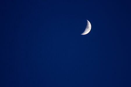 Crescent moon in the blue sky satellite crater copyspaceの写真素材