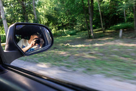 photographer traveler in the reflection of the car speed windowの写真素材