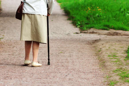 old woman with a stick is on the pathの写真素材