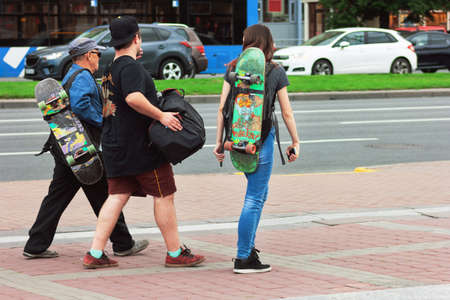 three skaters of different ages communicate and go for a rideの写真素材