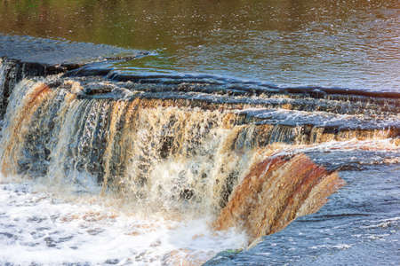 river comes out of the banks of the streams of water rock surfaceの写真素材