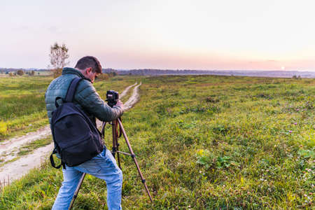 Photographer traveler adjusts the camera lifestyle professional activity hikerの写真素材