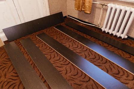 unpacking and assembling furniture components of bed slab particleboard constructの写真素材