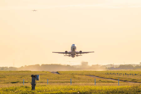 airplane take-off departure flight runway sunrise dustの写真素材