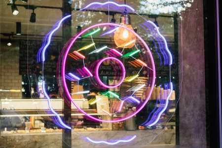 neon sign donut in the cafe window caseの写真素材