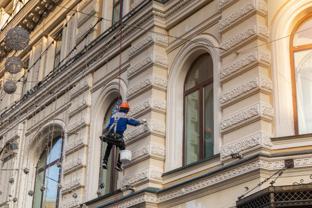 worker builder high-rise restores a historic building fasade .concept job