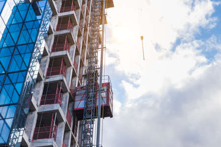 construction of a skyscraper fasade construction lift concrete and glass.concept new estateの写真素材