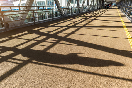 silhouette of a person with a phone in elevated passage corridor bridge concept communication...