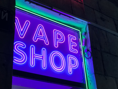 vape shop electronic cigarette neon colored window showcase sign lights glow up attracting customers on the street at night.concept vape shop.の写真素材