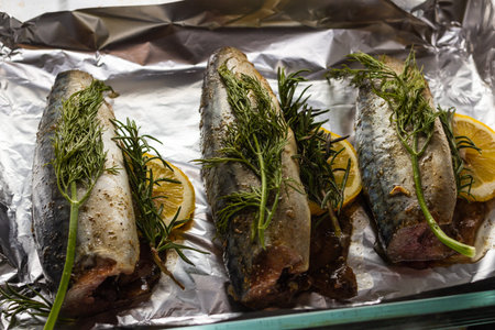 mackerel fish with rosemary and lemon dish, several objects, served lying on the sheet for baking in the oven in the kitchen.concept recipe fish with rosemary and lemon.の写真素材