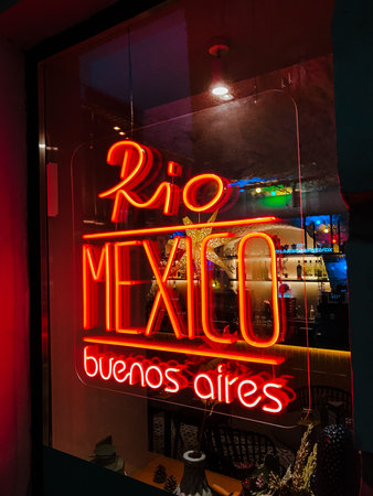 neon sign rio mexico buenos aires city, Latin American cuisine, billboard, red color, glows flickering, attracts visitors, window restaurant cafe at night. concept latin american cuisineの写真素材
