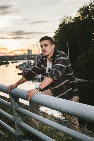 man caucasian model millionaire yachtsman in a shirt with a watch on his wrist, stands on the pier...
